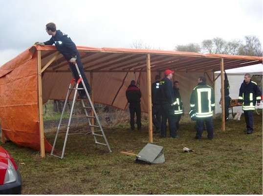 Kameraden beim Befestigen der Zeltplane
