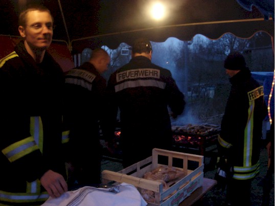 Kameraden beim Zubereiten von Bratwürsten