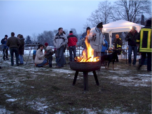 Weihnachtsbaumfeuer - Gäste an den Bistro-Tischen