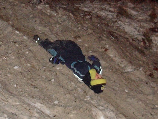 Weihnachtsbaumfeuer - Kinder rutschen im Schnee die Böschung herunter