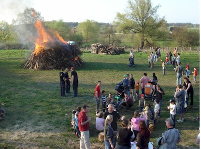 Festplatz mit Besuchern und brennendem Osterfeuer