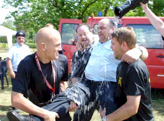 Der Wehrführer wird zum Wasserbehälter getragen