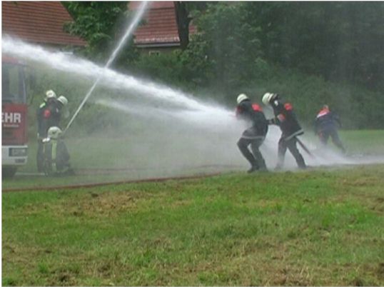 Feuerwehrmänner mit Löschschläuchen beim Löschangriff